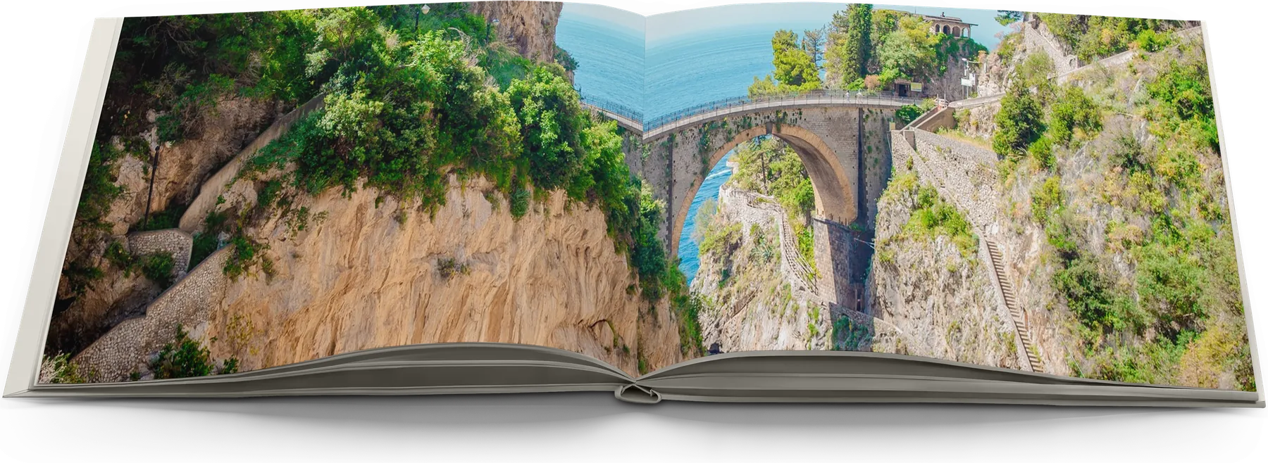 An open layflat photo book seen low across the pages: the bridge over the Furore gorge runs unbroken across both pages